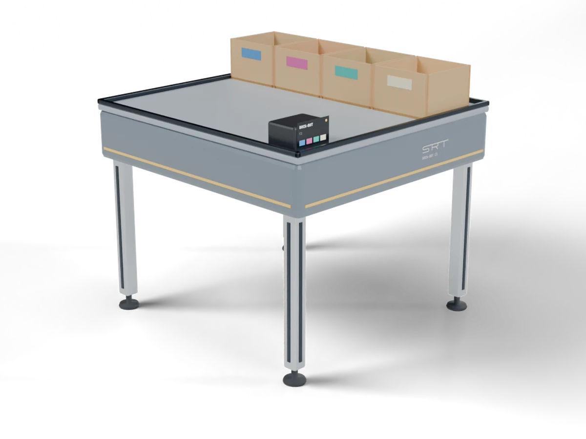 Dock-Bot: a grey docking table on four aluminium legs holding four cardboard destination boxes and a small status screen.